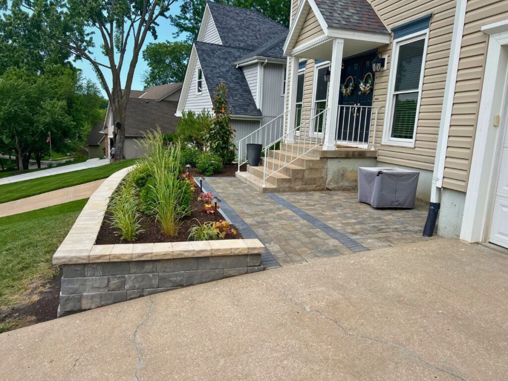 A brick walkway in front of a suburban home.